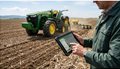 farmer-using-tablet-technology-near-tractor-in-field-photo