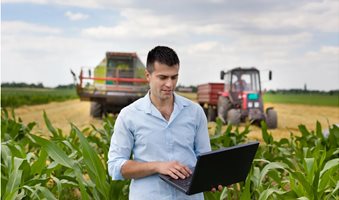 farmer-with-laptop-during-harvest-GettyImages-480915848