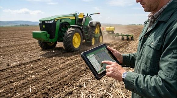 farmer-using-tablet-technology-near-tractor-in-field-photo