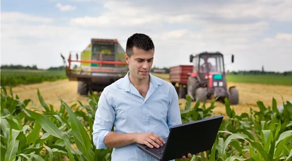 farmer-with-laptop-during-harvest-GettyImages-480915848