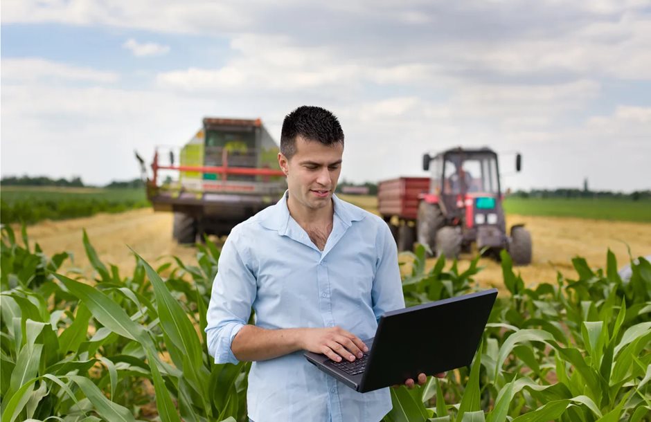 farmer-with-laptop-during-harvest-GettyImages-480915848